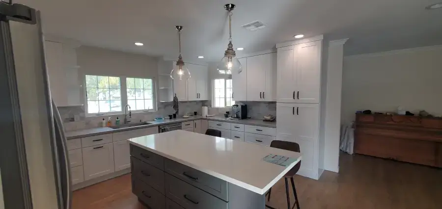 White kitchen with island and pendant lights